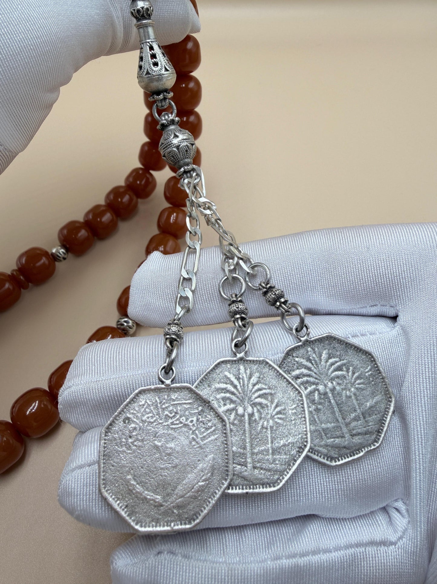 مسباح مسكي قديم، عرق أحمر، مع شرابة مميزة مزخرفة بالعملة العراقية القديمة وشرابة فضة عيار 500.