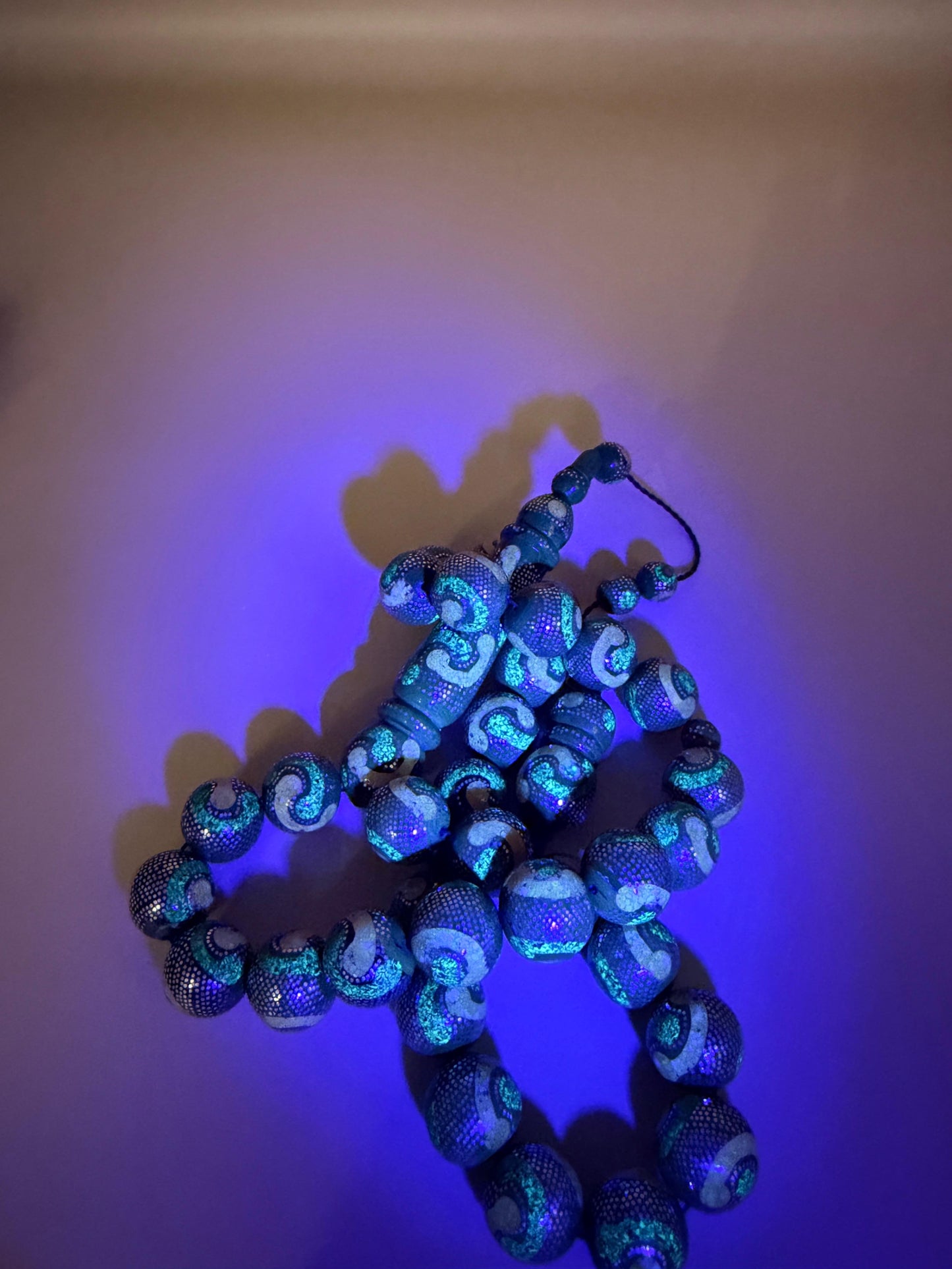 يسر بحر أحمر، مطعّم بالفضّة الخالصة عيار 925، ومزيّن بـ الكهرمان الطبيعي والملاكيت.
Red Sea Yusr, inlaid with 925 sterling silver, adorned with natural amber and malachite.