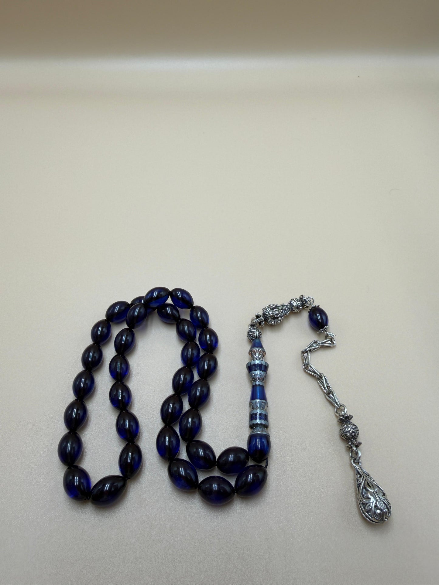 مسباح سندلوس أزرق، مأذنة مشغولة مميّزة. Blue Sandalwood Misbah with a Distinctive Handcrafted Minaret-Style Finial.