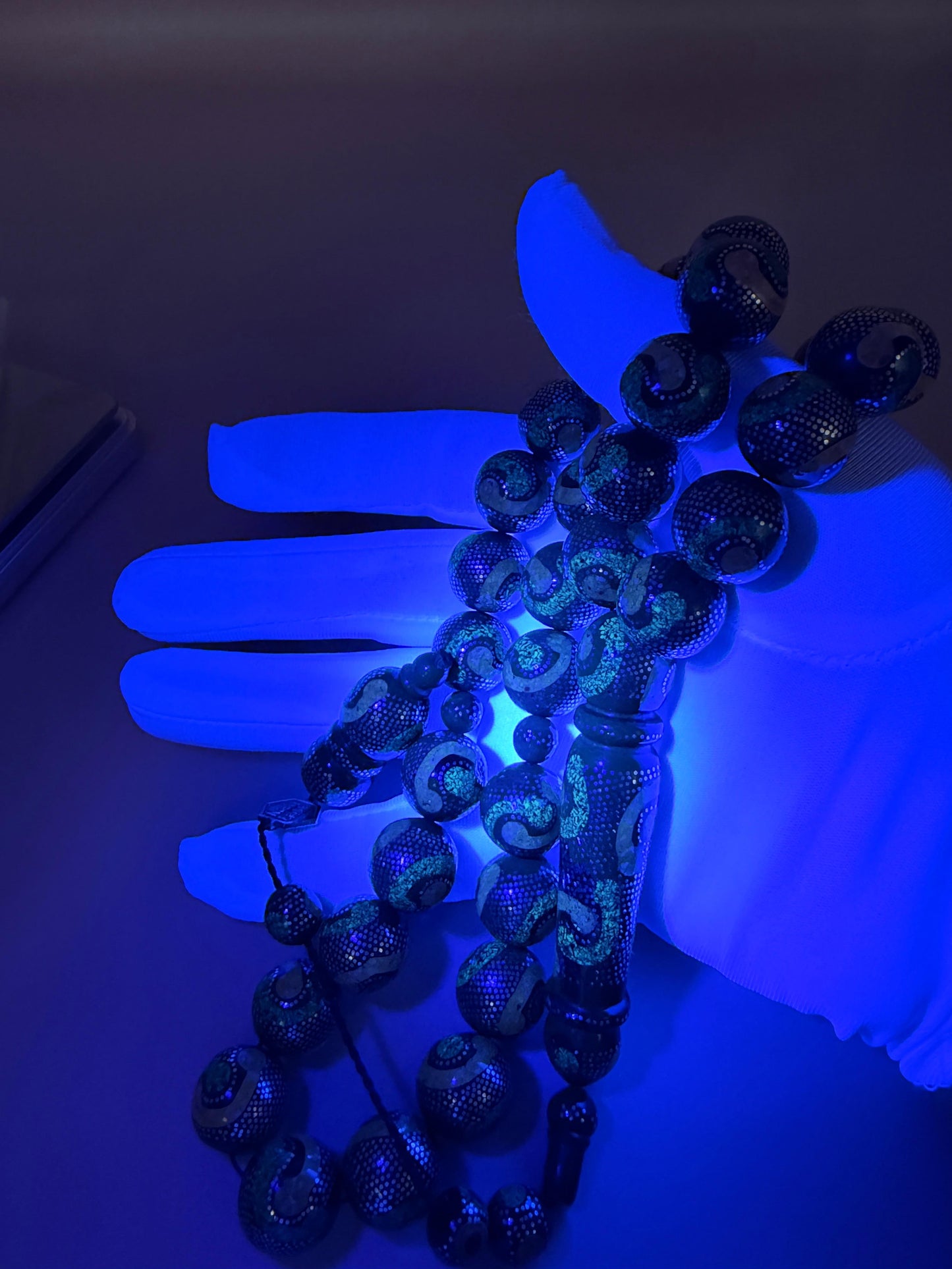 يسر بحر أحمر، مطعّم بالفضّة الخالصة عيار 925، ومزيّن بـ الكهرمان الطبيعي والملاكيت.
Red Sea Yusr, inlaid with 925 sterling silver, adorned with natural amber and malachite.