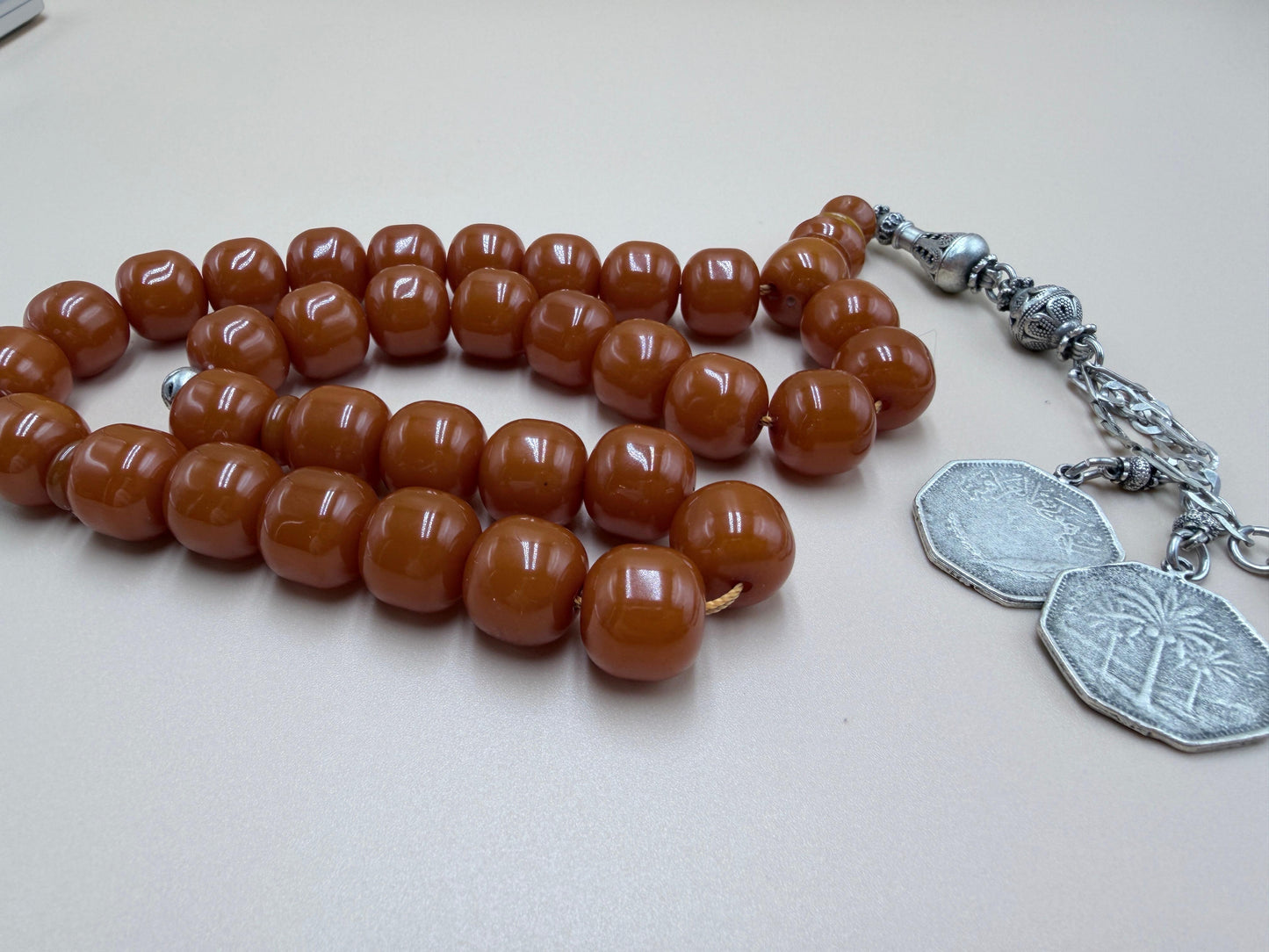 مسباح مسكي قديم، عرق أحمر، مع شرابة مميزة مزخرفة بالعملة العراقية القديمة وشرابة فضة عيار 500.