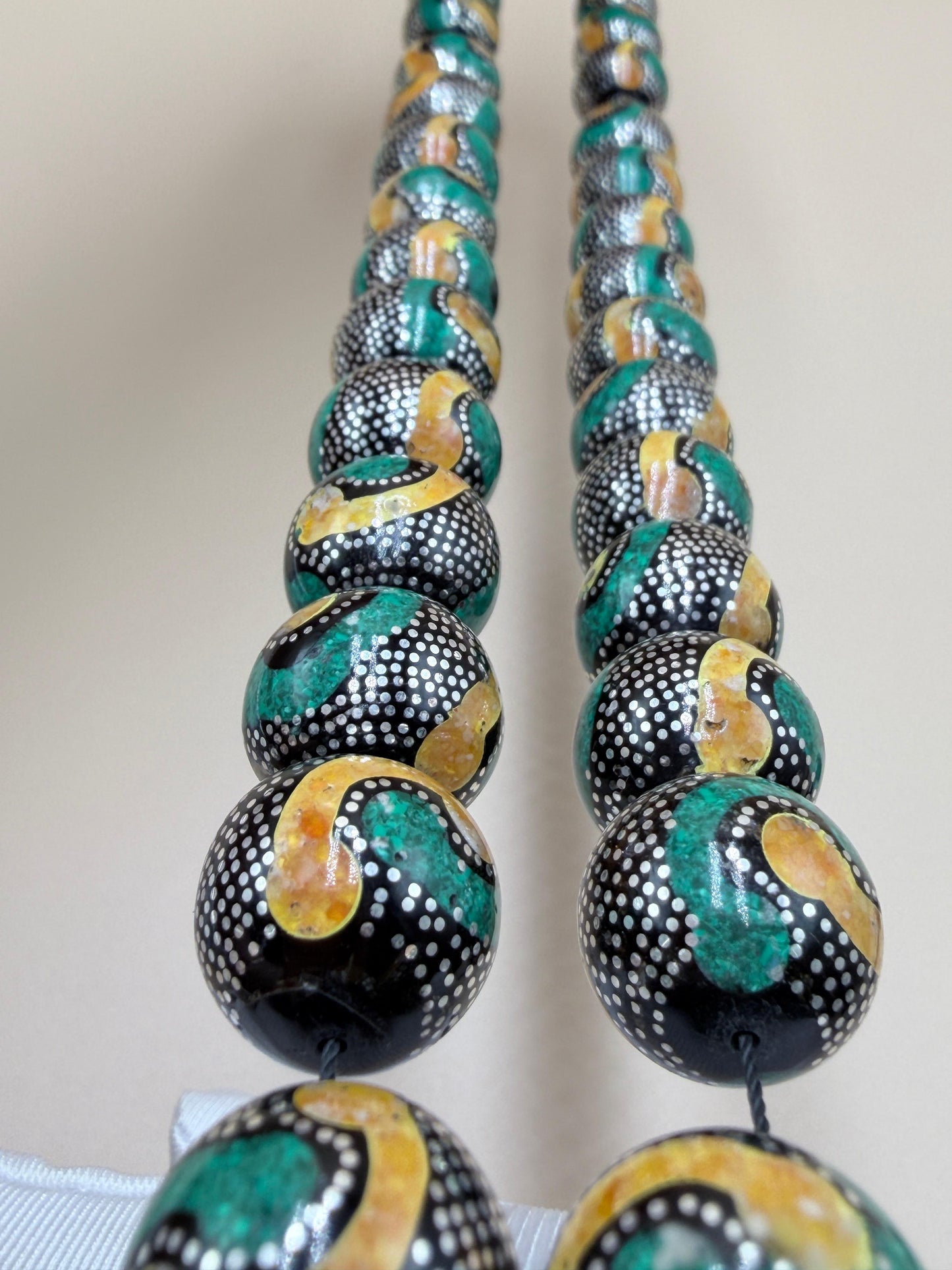 يسر بحر أحمر، مطعّم بالفضّة الخالصة عيار 925، ومزيّن بـ الكهرمان الطبيعي والملاكيت.
Red Sea Yusr, inlaid with 925 sterling silver, adorned with natural amber and malachite.