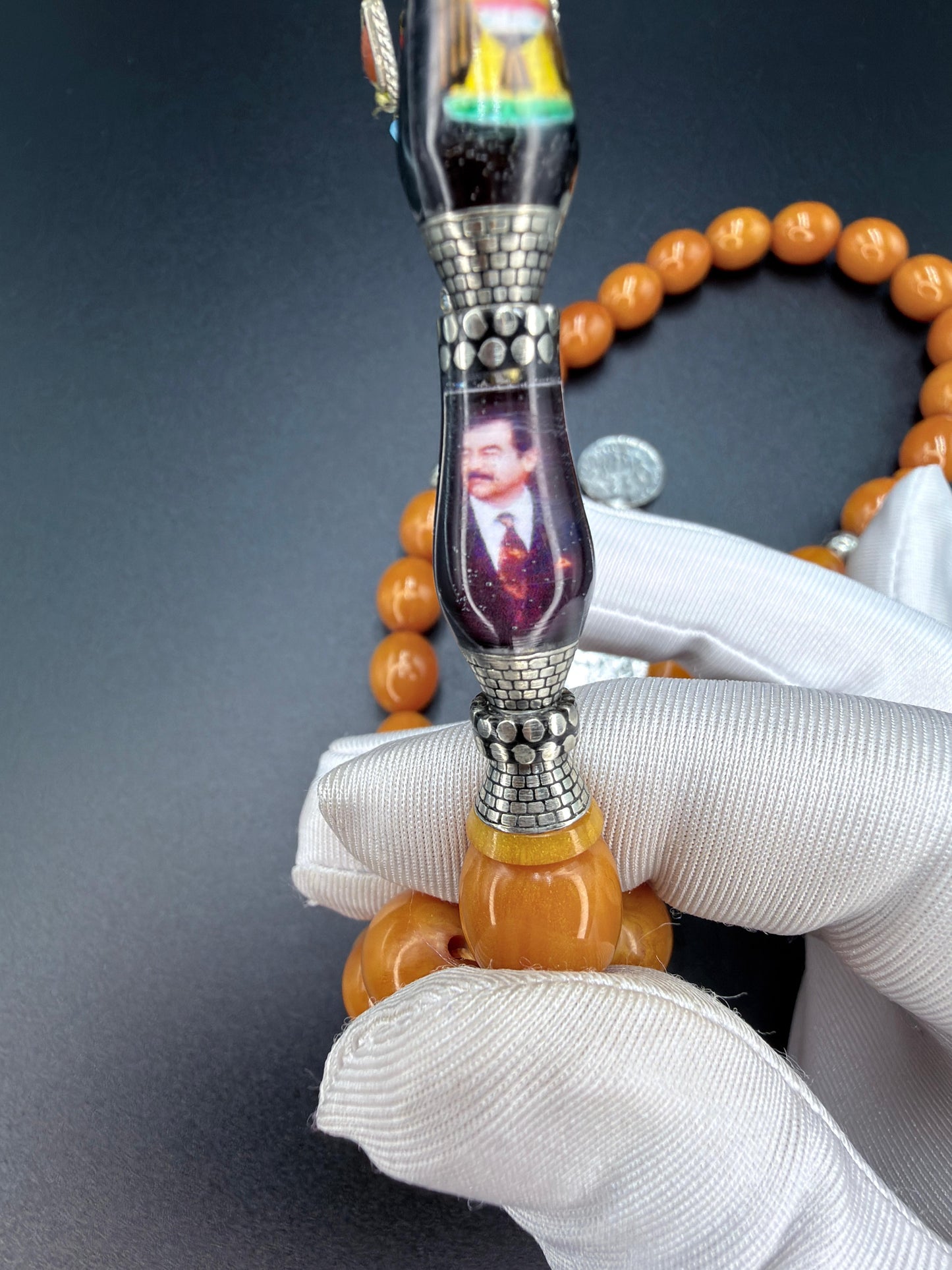 Unique musk Misbaha featuring the image of Saddam Hussein and the Iraqi national anthem, paired with a 500-grade silver tassel. مسباح مسكي مميّز يحمل صورة صدام حسين والسلام الجمهوري، مرفق بشرّابة فضّة عيار 500
