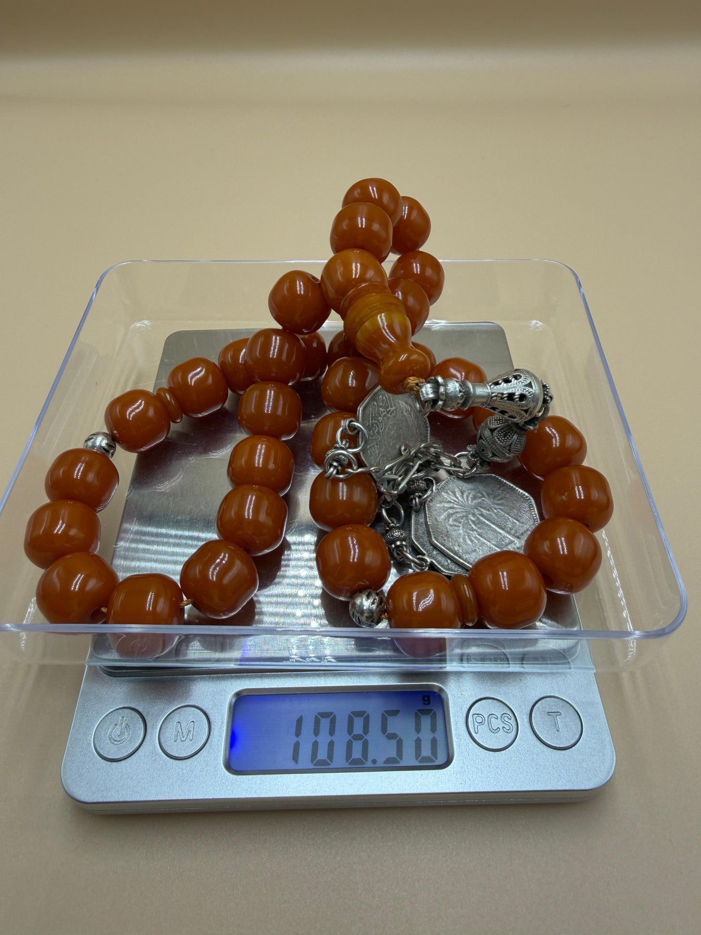 مسباح مسكي قديم، عرق أحمر، مع شرابة مميزة مزخرفة بالعملة العراقية القديمة وشرابة فضة عيار 500.