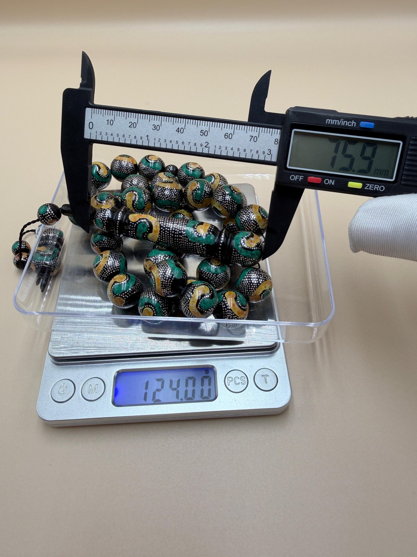 يسر بحر أحمر، مطعّم بالفضّة الخالصة عيار 925، ومزيّن بـ الكهرمان الطبيعي والملاكيت.
Red Sea Yusr, inlaid with 925 sterling silver, adorned with natural amber and malachite.