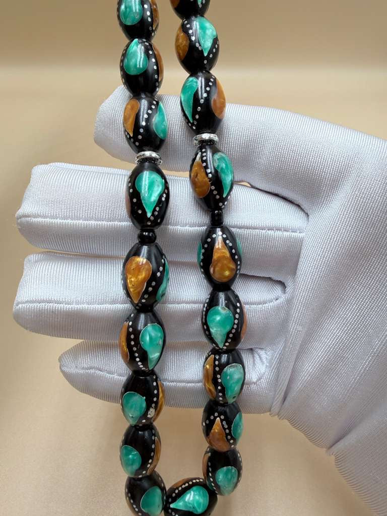 مسباح كوك، مطعّم بطحين الكهرمان وحجر المالاكيت والفضة. Kuka Wood Misbah, Inlaid with Amber Powder, Malachite Stone, and Silver.