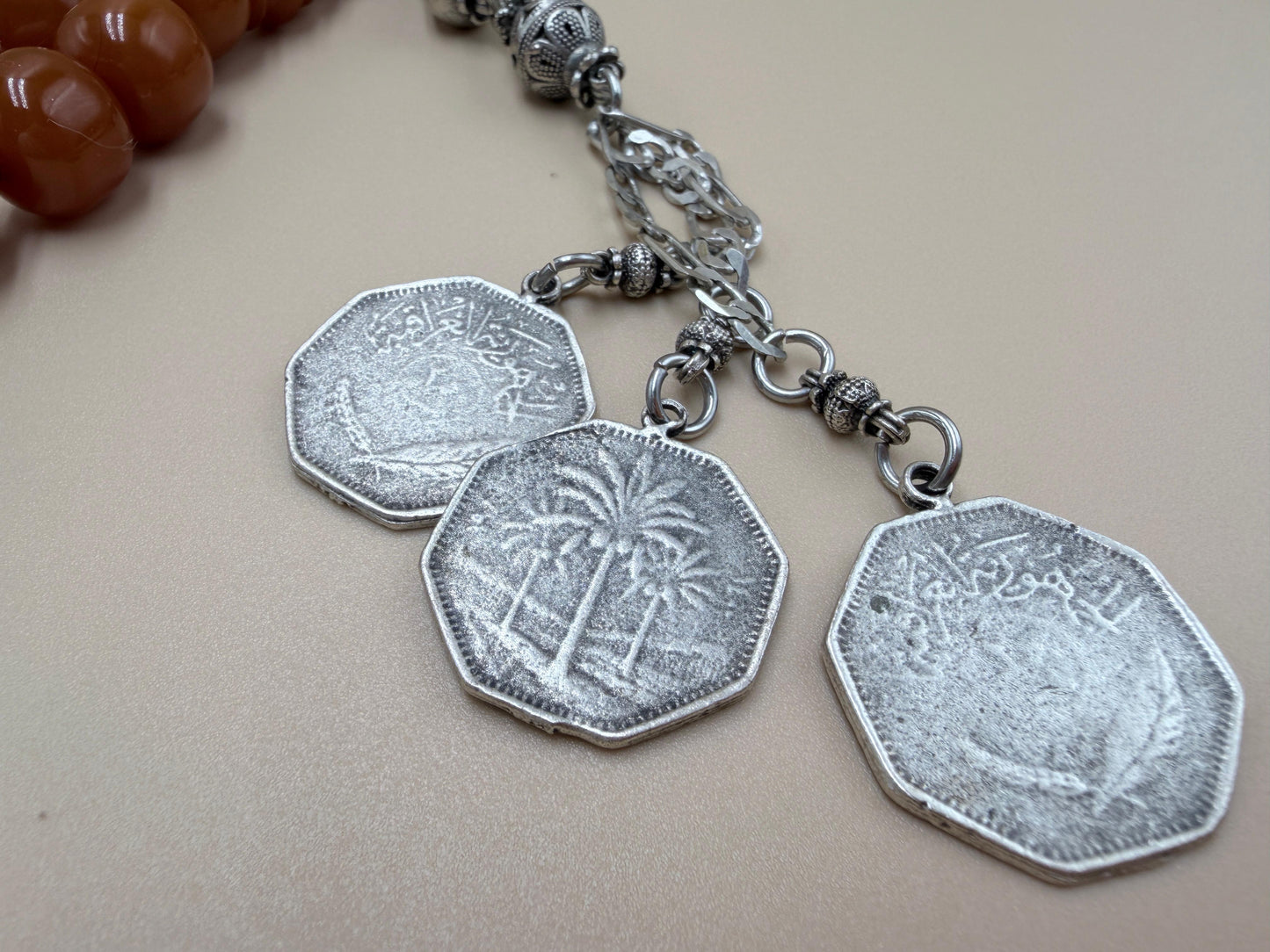 مسباح مسكي قديم، عرق أحمر، مع شرابة مميزة مزخرفة بالعملة العراقية القديمة وشرابة فضة عيار 500.