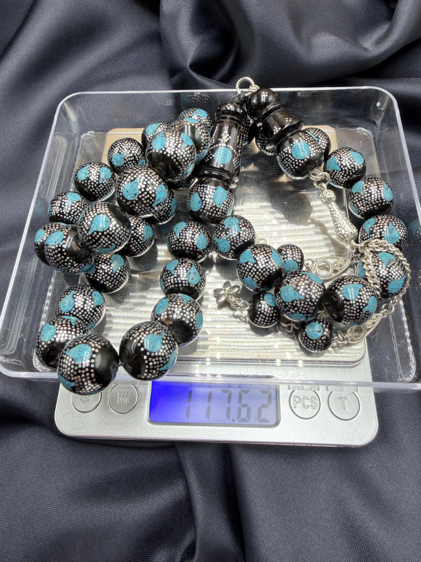 يسر بحر أحمر بتطعيم فضّة خالصة عيار 925، مع فيروز طبيعي، ومرفق بـ شرابة فضّة 925.
Red Sea Yusr inlaid with 925 sterling silver, featuring natural turquoise, completed with a 925 sterling silver tassel.