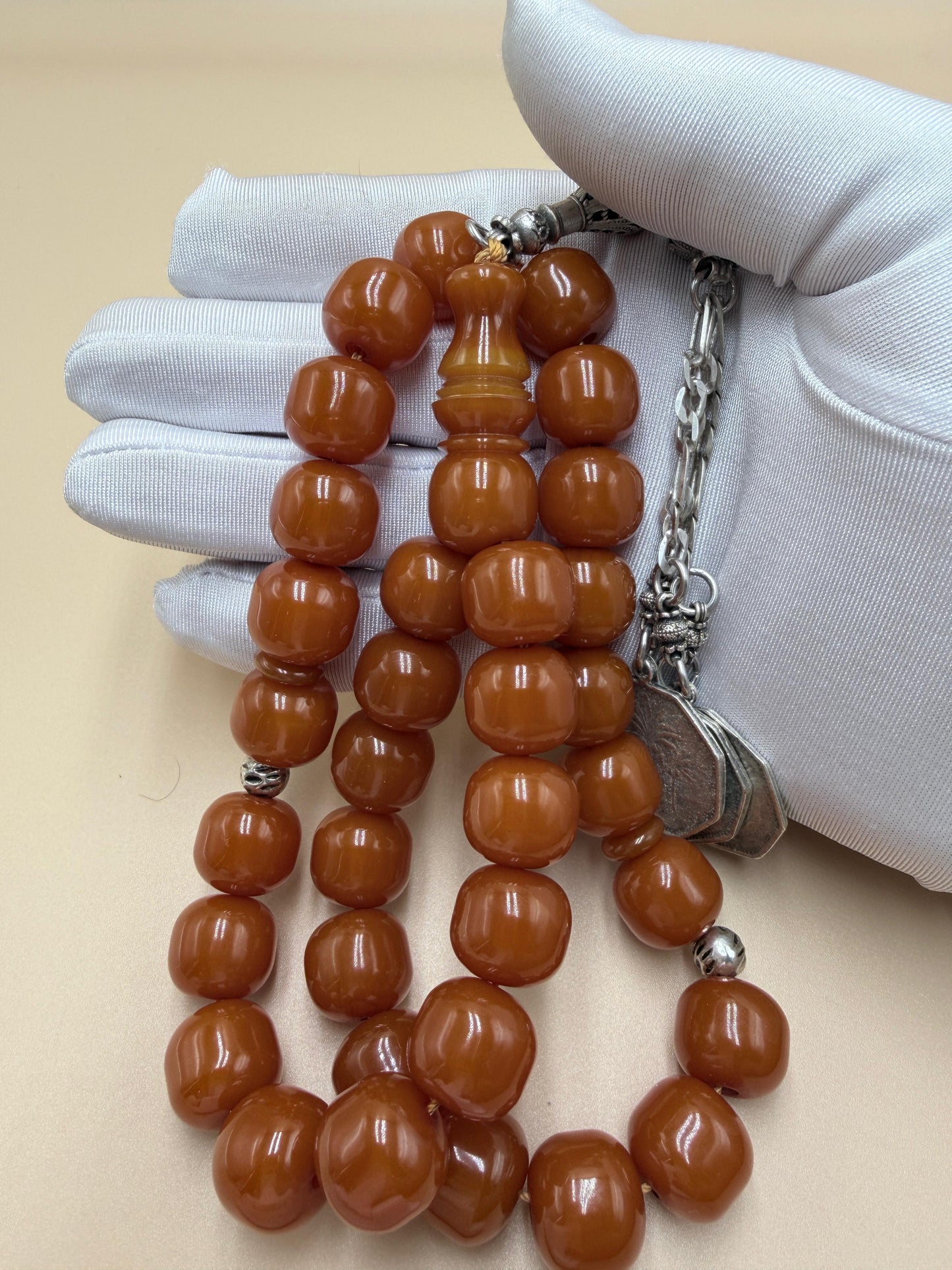 مسباح مسكي قديم، عرق أحمر، مع شرابة مميزة مزخرفة بالعملة العراقية القديمة وشرابة فضة عيار 500.