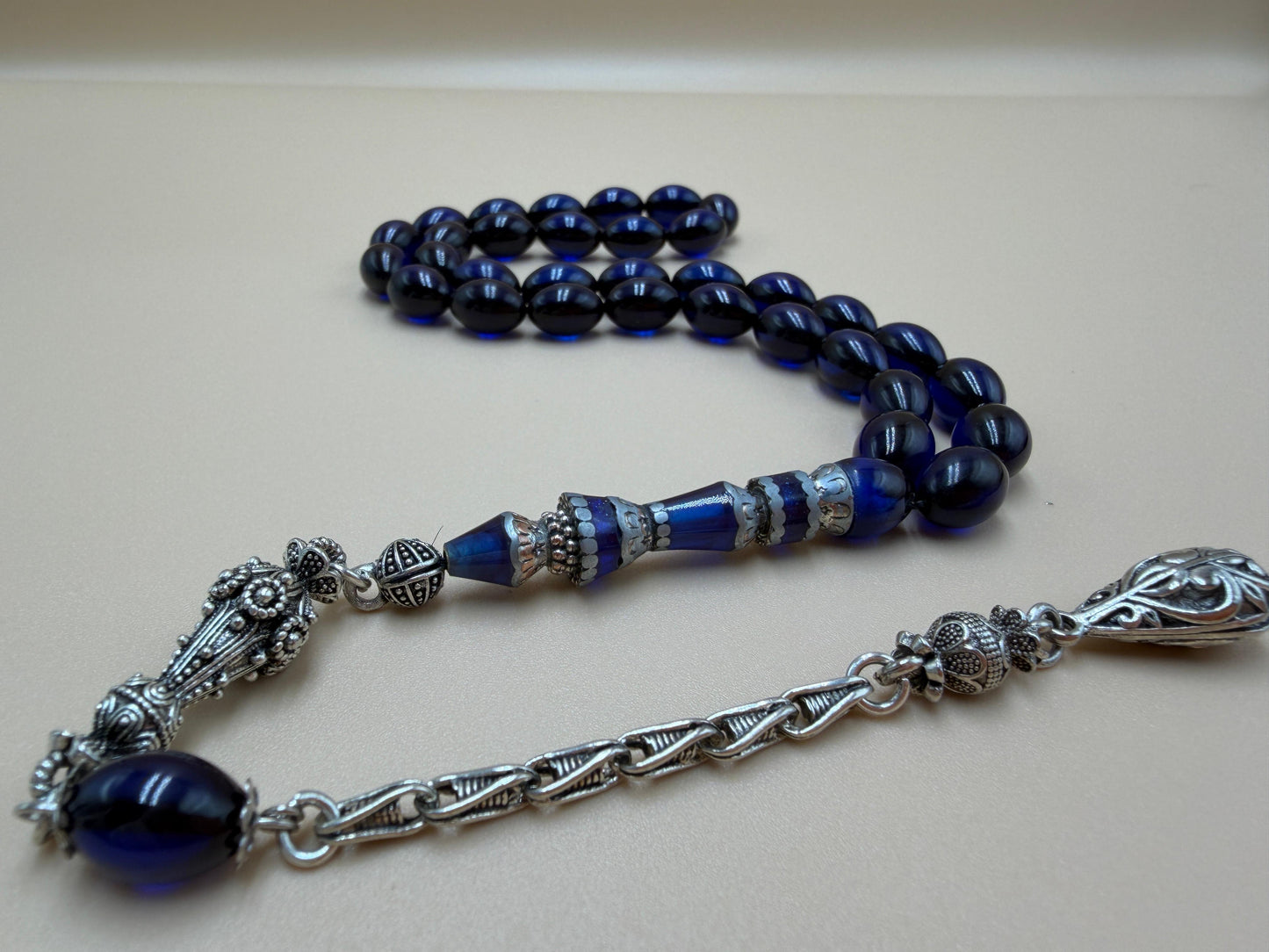 مسباح سندلوس أزرق، مأذنة مشغولة مميّزة. Blue Sandalwood Misbah with a Distinctive Handcrafted Minaret-Style Finial.