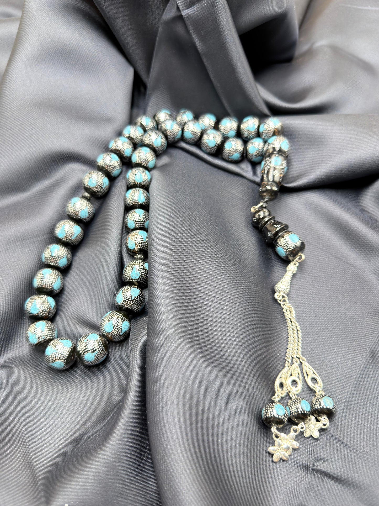 يسر بحر أحمر بتطعيم فضّة خالصة عيار 925، مع فيروز طبيعي، ومرفق بـ شرابة فضّة 925.
Red Sea Yusr inlaid with 925 sterling silver, featuring natural turquoise, completed with a 925 sterling silver tassel.