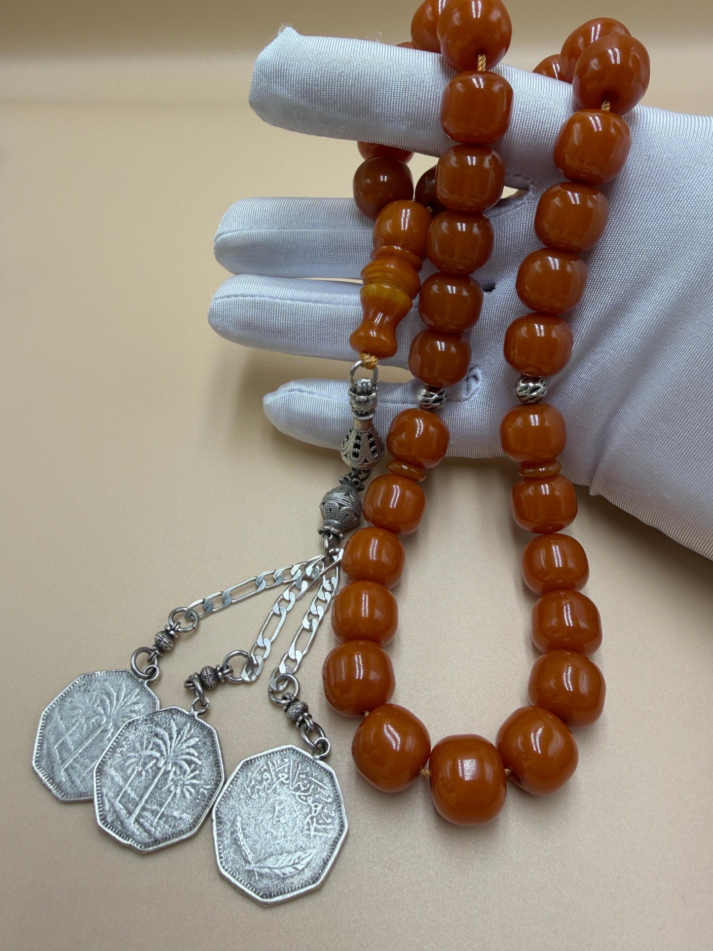 مسباح مسكي قديم، عرق أحمر، مع شرابة مميزة مزخرفة بالعملة العراقية القديمة وشرابة فضة عيار 500.