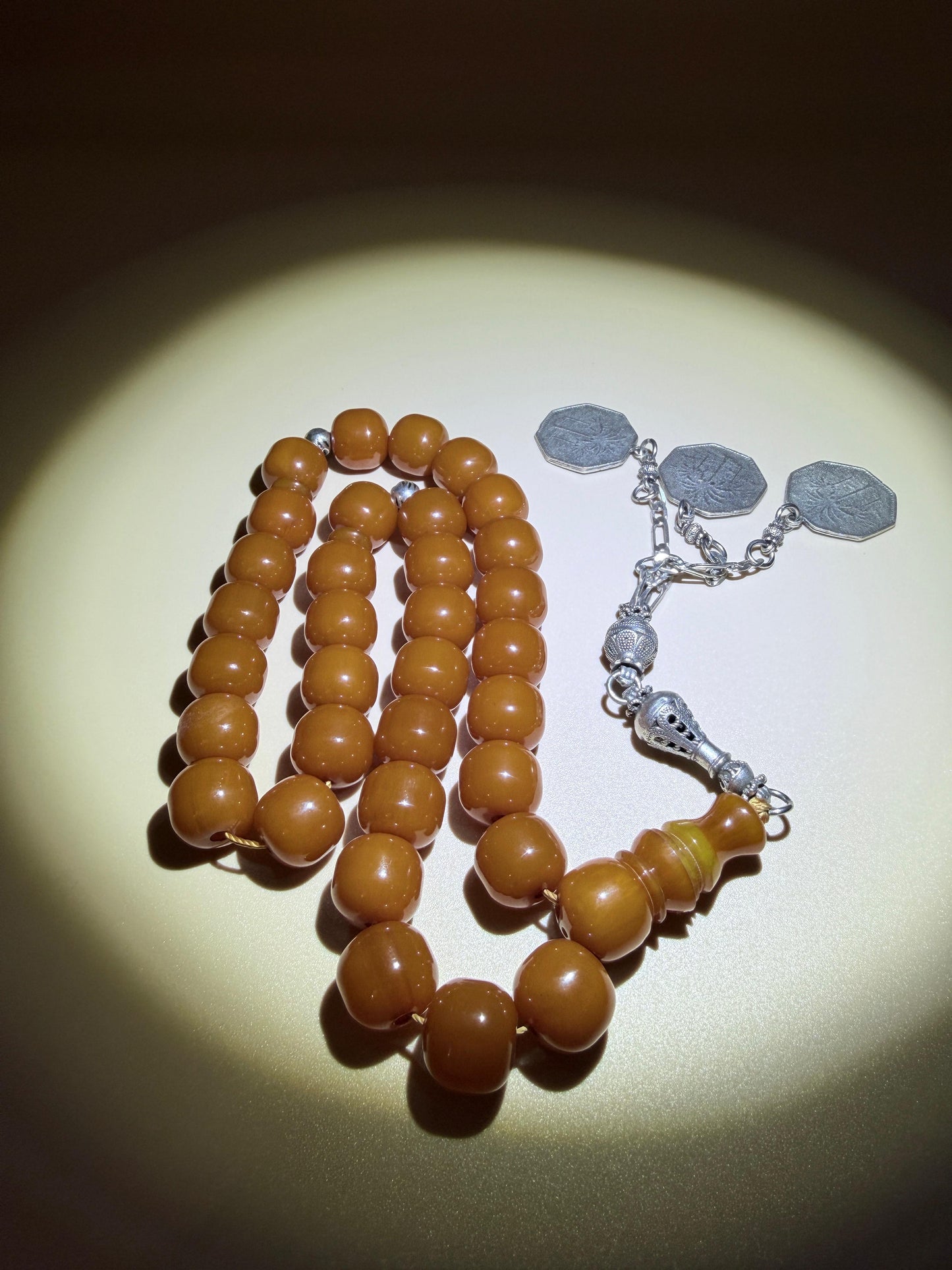 مسباح مسكي قديم، عرق أحمر، مع شرابة مميزة مزخرفة بالعملة العراقية القديمة وشرابة فضة عيار 500.