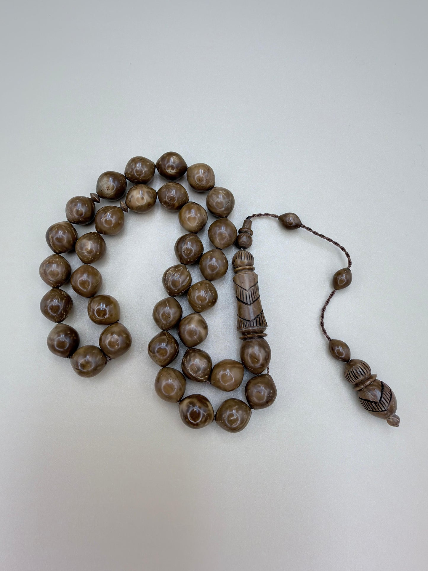 مسباح نارجيل (كوك) مع شاهد منحوت يدوياً 
Coconut (Koka) Misbaha with a hand-carved shahid bead, crafted with artistic detail.