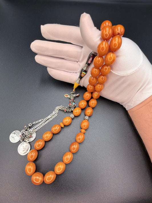 Unique musk Misbaha featuring the image of Saddam Hussein and the Iraqi national anthem, paired with a 500-grade silver tassel. مسباح مسكي مميّز يحمل صورة صدام حسين والسلام الجمهوري، مرفق بشرّابة فضّة عيار 500