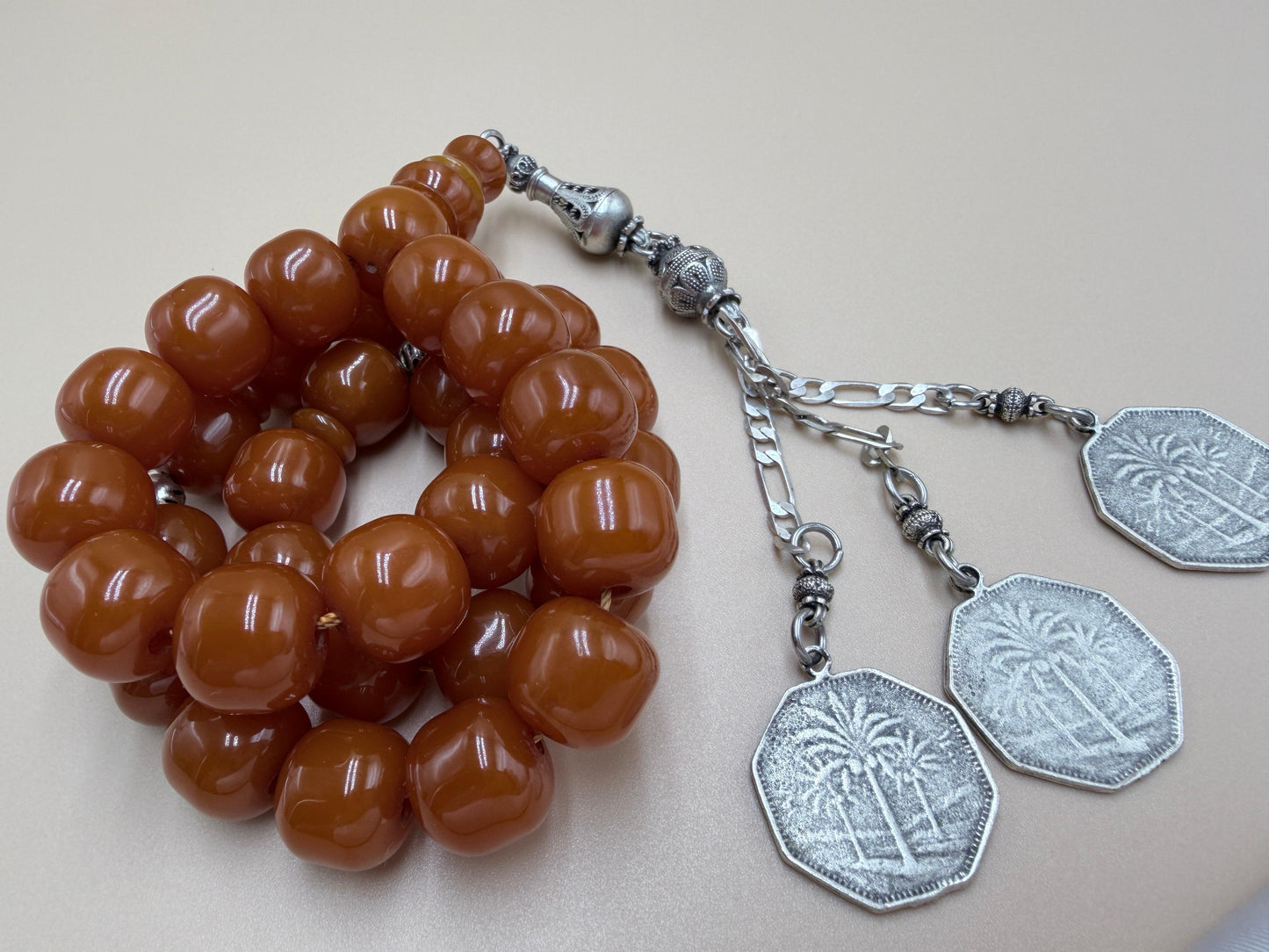 مسباح مسكي قديم، عرق أحمر، مع شرابة مميزة مزخرفة بالعملة العراقية القديمة وشرابة فضة عيار 500.