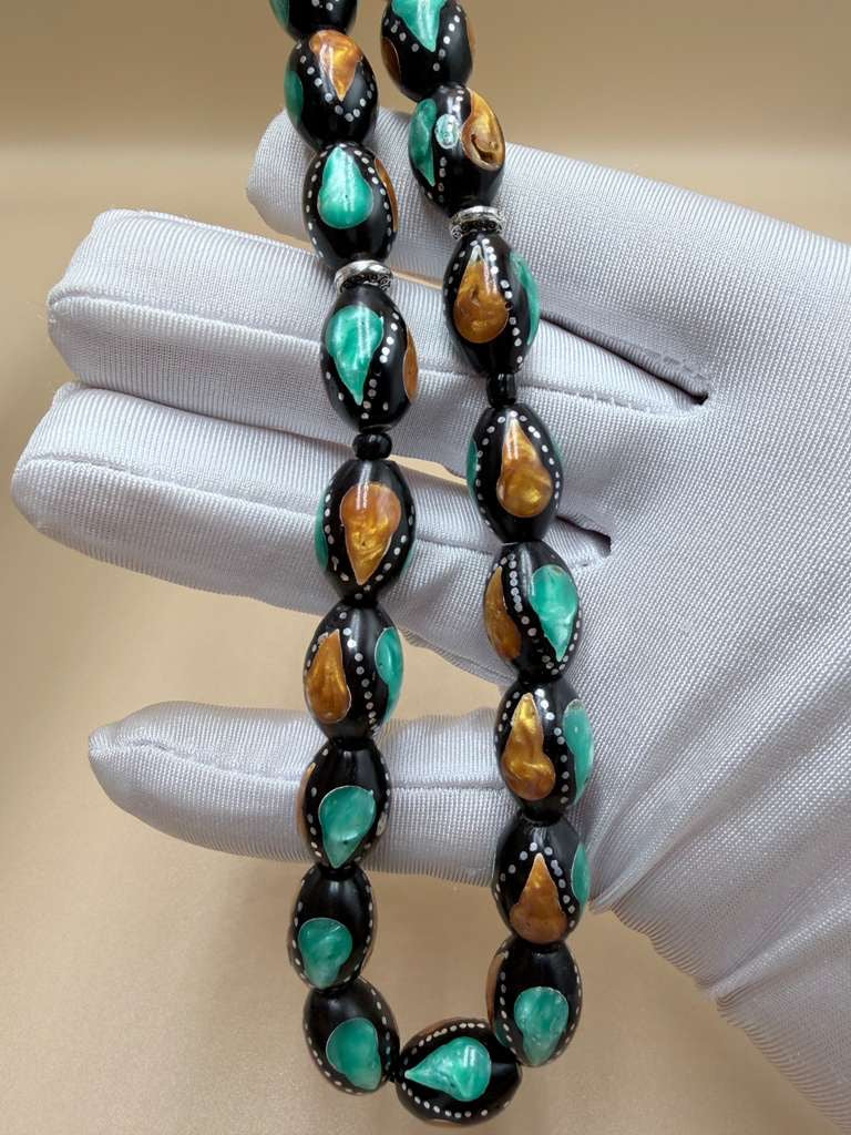 مسباح كوك، مطعّم بطحين الكهرمان وحجر المالاكيت والفضة. Kuka Wood Misbah, Inlaid with Amber Powder, Malachite Stone, and Silver.